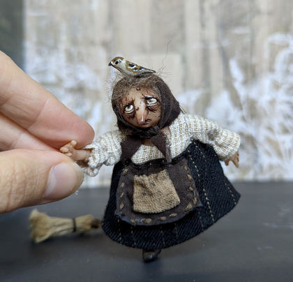 Close-up detail of a handmade gothic miniature — Small Baba Yaga with bird