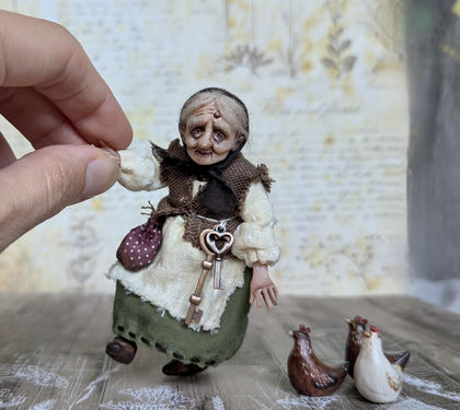 Close-up detail of a handmade gothic miniature — Small art doll Granny with hen