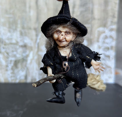 Close-up detail of a handmade gothic miniature — Small doll Witch, Polymer clay, acrylic paint, varnish, wire, fabric, wool